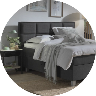 Antraciet boxspring in een lichte slaapkamer